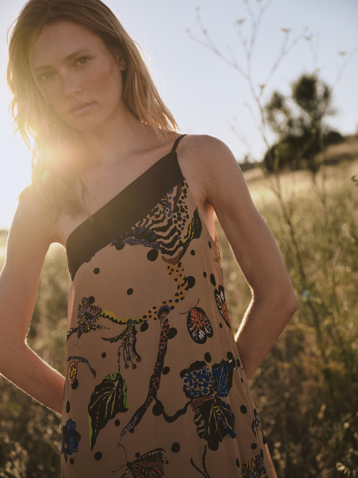 Vestido Lauren beige visto de lado, estampado de plantas y bajo asimétrico