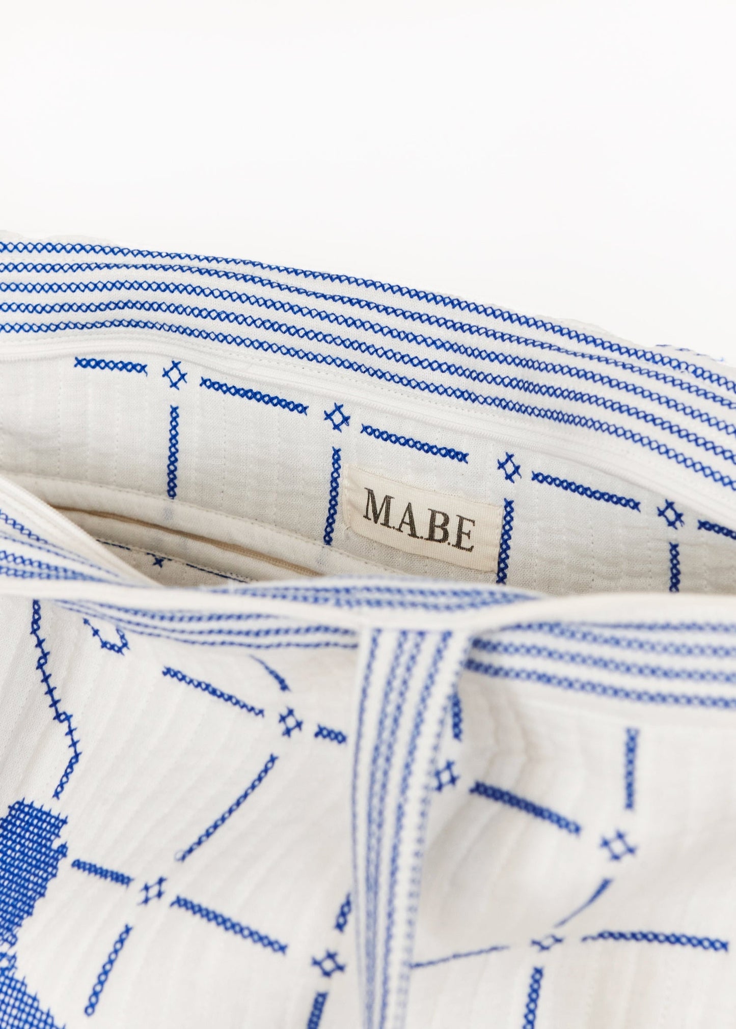 Bolso tote en marfil con bordados en azul, detalle – Mabe · PORTICO Concept, Turó Park Barcelona