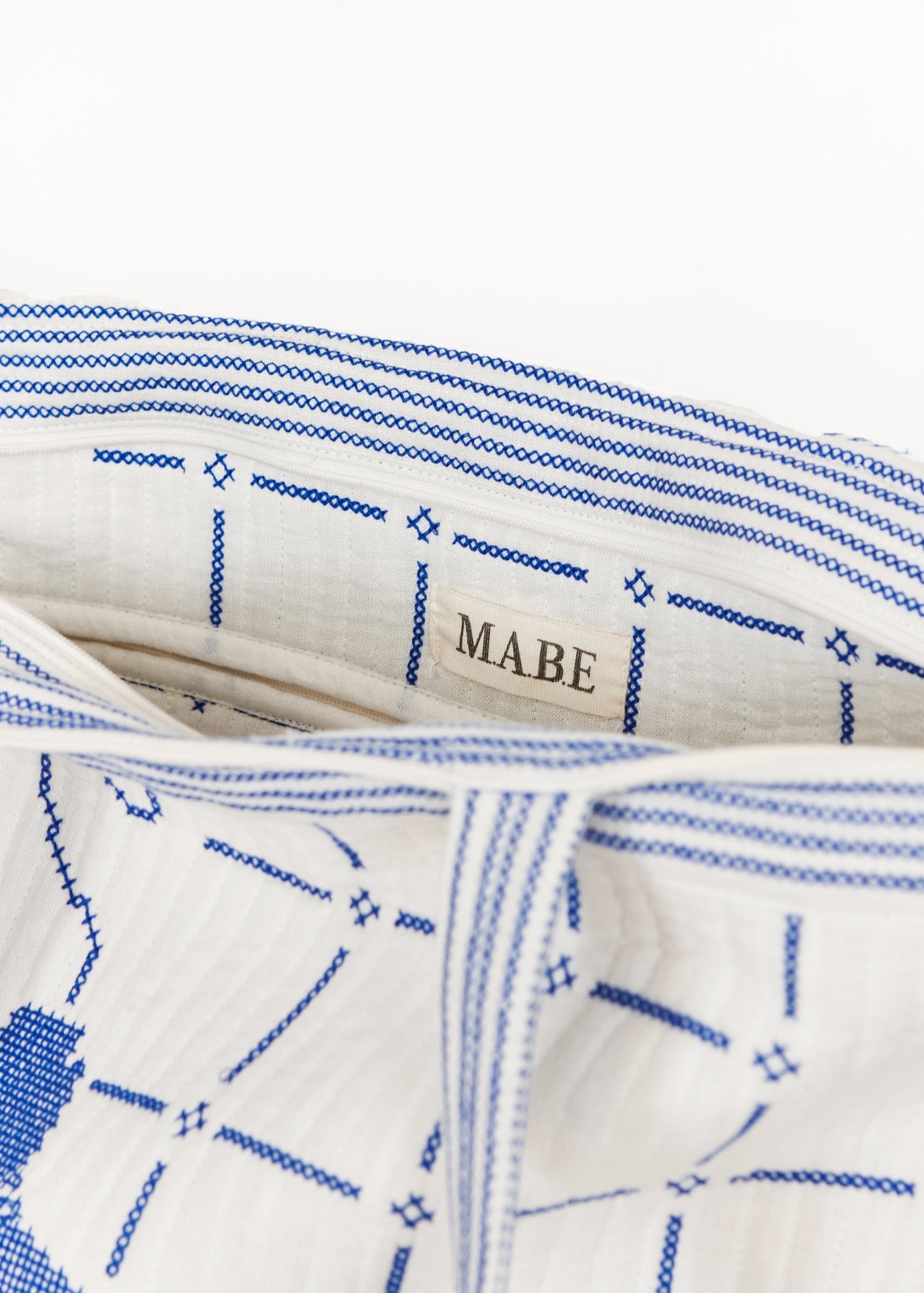 Bolso tote en marfil con bordados en azul, detalle – Mabe · PORTICO Concept, Turó Park Barcelona