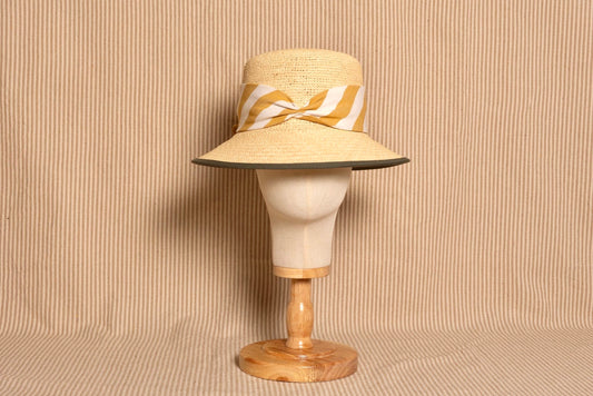 Bucket de paja natural con lazo a rayas mostaza – Alexia Álvarez de Toledo · PORTICO Concept, Turó Park Barcelona